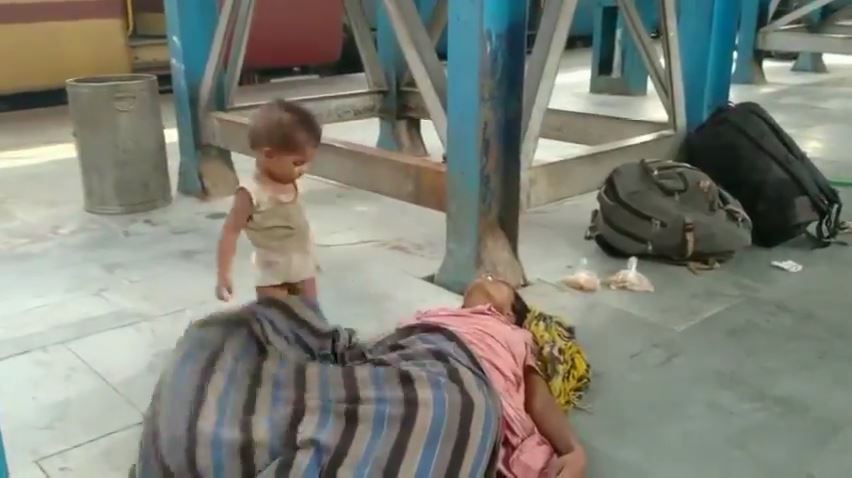 インド　母親が死亡した隣で遊ぶ赤ちゃん